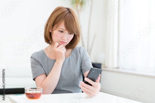 Photo: スマートフォンを見る女性 スマートフォンを見る女性