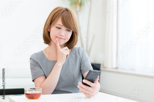 Photo: スマートフォンを見る女性 スマートフォンを見る女性