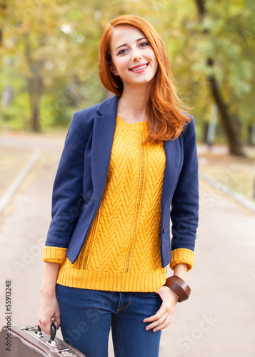 Photo: Girl with suitcase at autumn outdoor Girl with suitcase at autumn outdoor