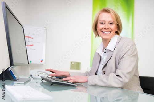 Photo: versicherungsangestellte sitzt am computer versicherungsangestellte sitzt am computer