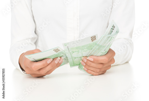 Photo: Close up of female hands counting money isolated on white Close up of female hands counting money isolated on white