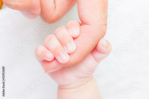 Photo: baby hand holding adult finger baby hand holding adult finger