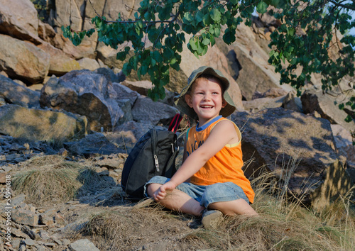 Photo: Happy little boy resting after hiking expedition Happy little boy resting after hiking expedition