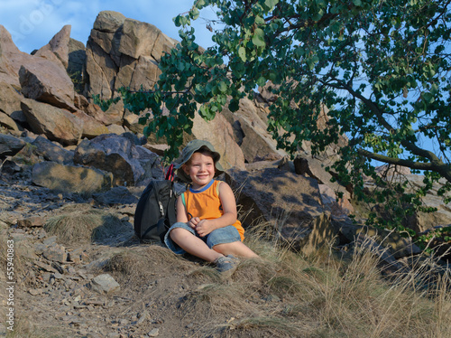 Photo: Little boy resting on the mountain in summer Little boy resting on the mountain in summer