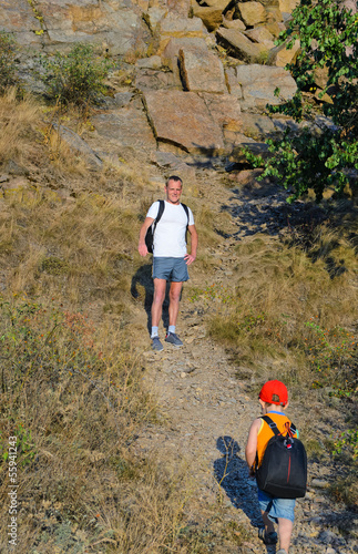 Photo: Father waiting for his small son while hiking Father waiting for his small son while hiking