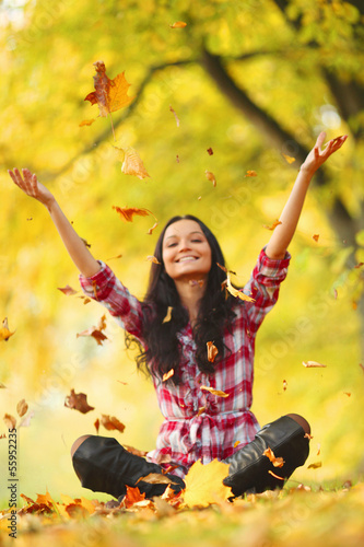 Photo: woman drop leaves in autumn park woman drop leaves in autumn park