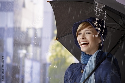 Photo: Happy young woman under umbrella in rain Happy young woman under umbrella in rain