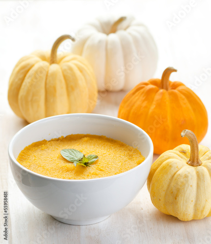 Photo: Pumpkin porridge and pumpkins on white wooden table Pumpkin porridge and pumpkins on white wooden table