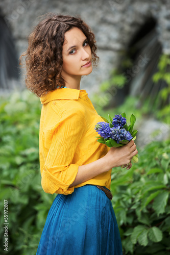 Photo: Sad young woman with bouquet of flowers Sad young woman with bouquet of flowers