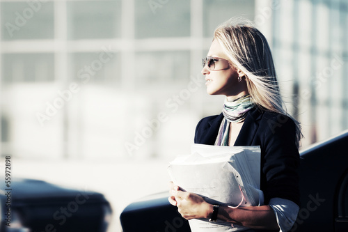 Photo: Young business woman with financial papers Young business woman with financial papers