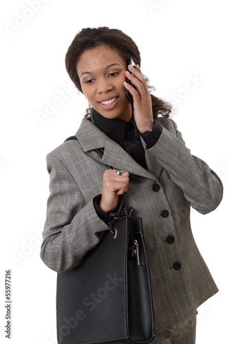 Photo: Ethnic businesswoman with mobile and bag Ethnic businesswoman with mobile and bag