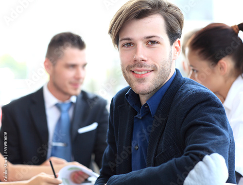 Photo: Happy businessman sitting in office Happy businessman sitting in office