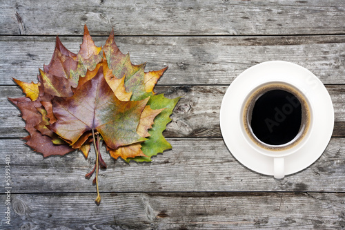 Photo: coffee and maple leaves on wooden table coffee and maple leaves on wooden table