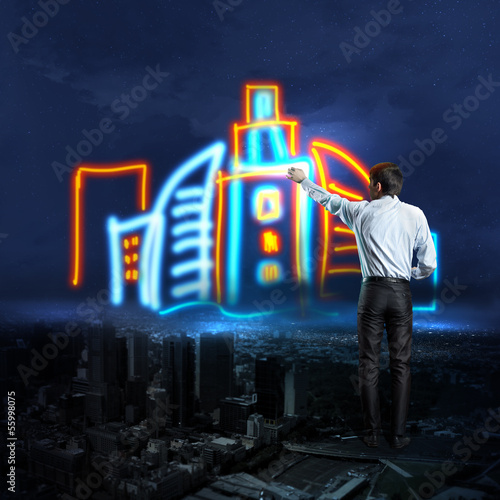 Photo: Businessman draws a glowing signs Businessman draws a glowing signs