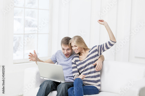 Photo: young caucasian couple sitting on couch young caucasian couple sitting on couch