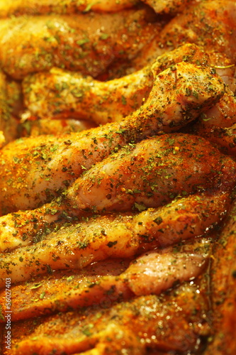 Photo: Closeup raw marinated chicken meat drumstick Closeup raw marinated chicken meat drumstick