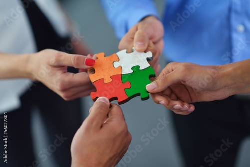 Photo: Group of business people assembling jigsaw puzzle Group of business people assembling jigsaw puzzle