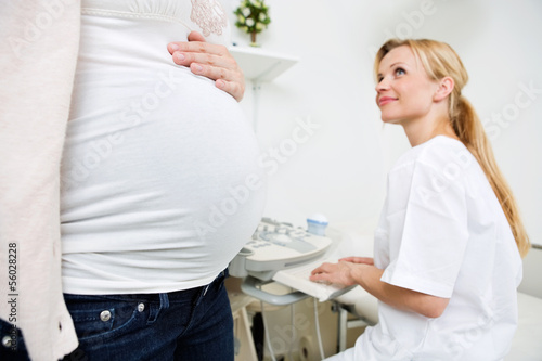Photo: Pregnant Woman With Doctor Preparing For Ultrasound Scan Pregnant Woman With Doctor Preparing For Ultrasound Scan
