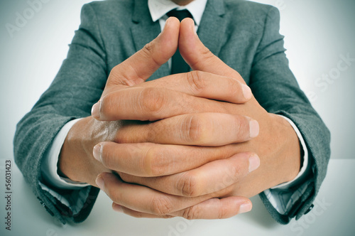 Photo: man in suit with clasped hands man in suit with clasped hands