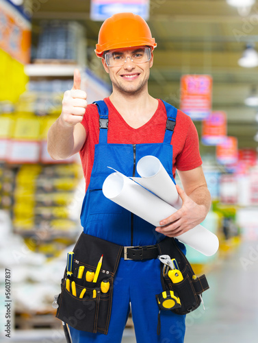 Photo: handyman with paper showing thumbs up sign handyman with paper showing thumbs up sign