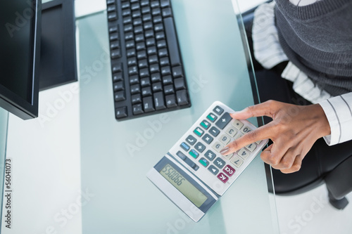Photo: Close up on businesswoman using calculator Close up on businesswoman using calculator