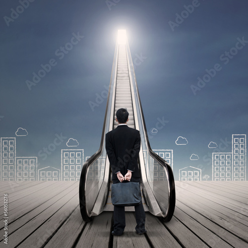 Photo: Businessman at escalator with city drawing Businessman at escalator with city drawing