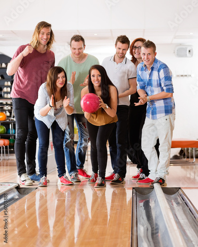 Photo: Woman Bowling While Friends Cheering Woman Bowling While Friends Cheering