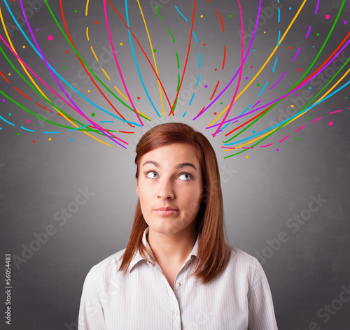 Photo: Young girl thinking with colorful abstract lines overhead Young girl thinking with colorful abstract lines overhead