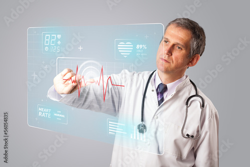 Photo: Middle aged doctor pressing modern medical type of button Middle aged doctor pressing modern medical type of button