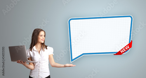 Photo: young woman holding a laptop and presenting modern speech bubble young woman holding a laptop and presenting modern speech bubble
