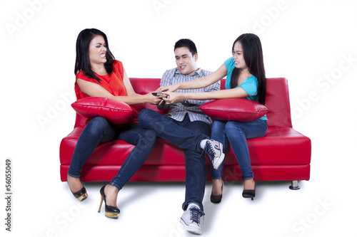 Photo: Three young teenagers fighting for remote control Three young teenagers fighting for remote control