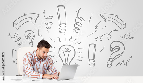 Photo: Young businessman brainstorming with drawn arrows and symbols Young businessman brainstorming with drawn arrows and symbols