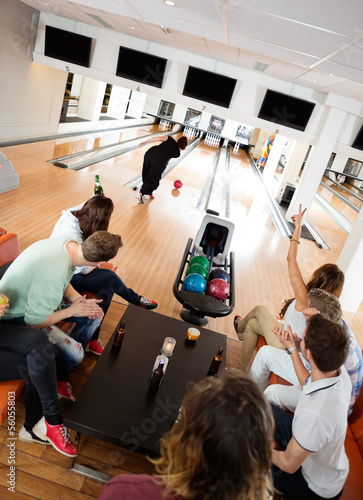 Photo: Friends Cheering Woman Bowling in Club Friends Cheering Woman Bowling in Club