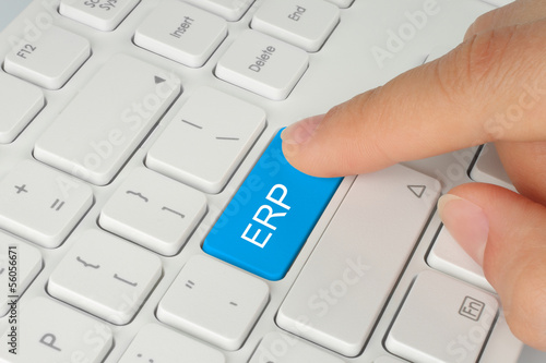 Photo: Hand pushing blue ERP button on white keyboard background . Hand pushing blue ERP button on white keyboard background .