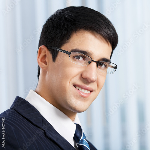 Photo: Happy smiling businessman at office Happy smiling businessman at office