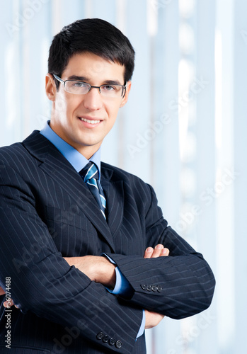 Photo: Portrait of smiling businessman at office Portrait of smiling businessman at office
