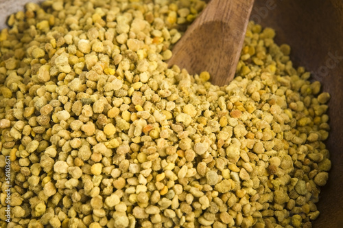 Photo: Bee pollen in wooden scoop. Nutritional supplement Bee pollen in wooden scoop. Nutritional supplement