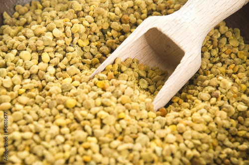Photo: Bee pollen in wooden scoop. Nutritional supplement Bee pollen in wooden scoop. Nutritional supplement