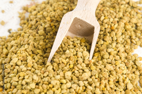 Photo: Bee pollen in wooden scoop. Nutritional supplement Bee pollen in wooden scoop. Nutritional supplement