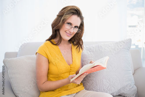 Photo: Smiling woman wearing glasses holding book Smiling woman wearing glasses holding book