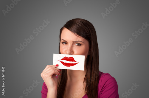 Photo: Happy pretty woman holding card with kiss lipstick mark Happy pretty woman holding card with kiss lipstick mark