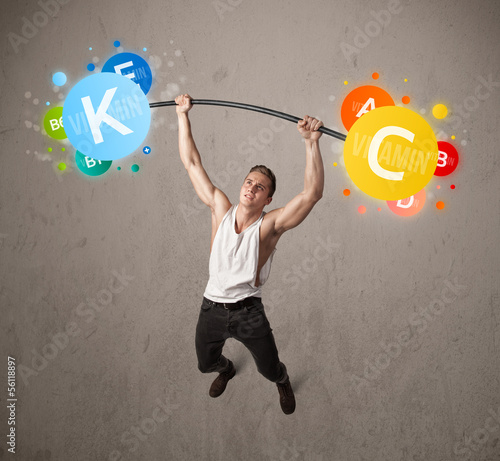Photo: muscular man lifting colorful vitamin weights muscular man lifting colorful vitamin weights
