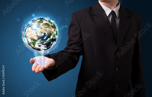 Photo: Businessman holding glowing earth globe Businessman holding glowing earth globe