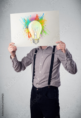 Photo: Businessman holding a cardboard with paint splashes and lightbul Businessman holding a cardboard with paint splashes and lightbul