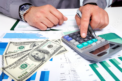 Photo: Hands of businessman with calculator. Hands of businessman with calculator.