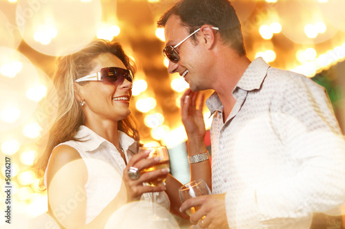 Photo: Adult couple enjoying nightlife with glasses of champagne Adult couple enjoying nightlife with glasses of champagne