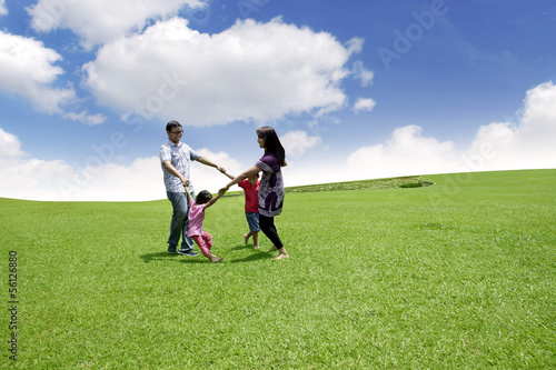 Photo: Happy asian family playing on the field Happy asian family playing on the field
