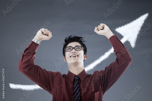 Photo: Successful businessman and up arrow sign Successful businessman and up arrow sign