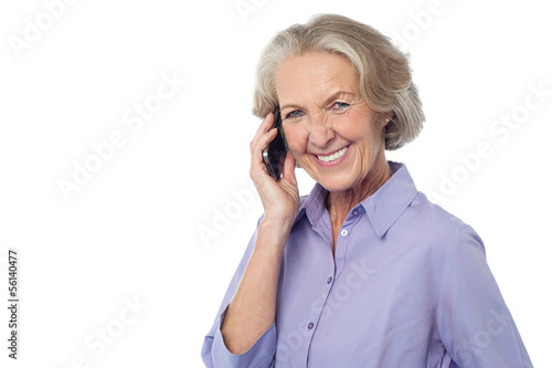 Photo: Senior smiling lady attending phone call Senior smiling lady attending phone call