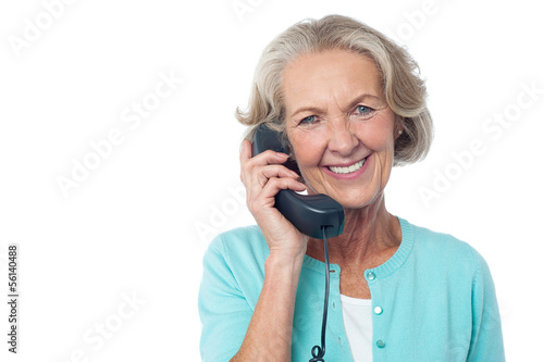 Photo: Senior lady holding phone receiver Senior lady holding phone receiver